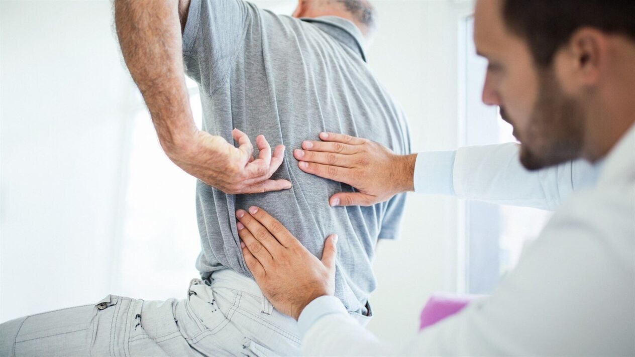 médico examina as costas con osteocondrose lumbar